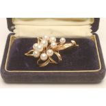 A MIKIMOTO CULTURED PEARL AND 14KT GOLD BROOCH, of abstract leaf form, set with ten graduated