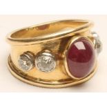 A RUBY AND DIAMOND COCKTAIL RING, centrally open back collet set with an oval polished ruby cabochon