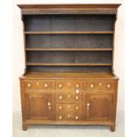 A GEORGIAN OAK DRESSER, early 19th century, the associated delft rack with moulded cornice and