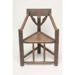 AN OAK TURNERS CHAIR, c.1900, of typical triangular form with chip carved top rail on ring and