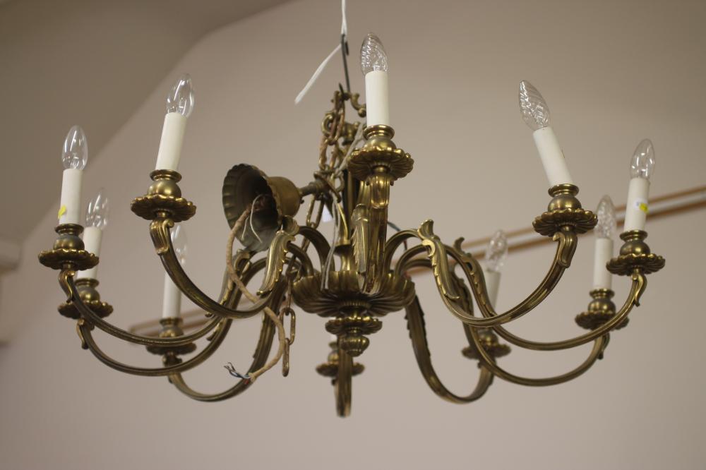 A BRASS CHANDELIER, c.1900, the lobed open work baluster turned stem issuing ten scrolled leaf