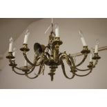 A BRASS CHANDELIER, c.1900, the lobed open work baluster turned stem issuing ten scrolled leaf
