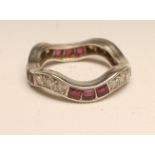A RUBY AND DIAMOND ETERNITY RING, the wavy band alternately set with three channel set square cut