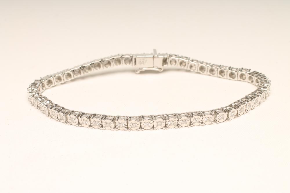 A DIAMOND TENNIS BRACELET, the fifty illusion set stones each of approximately 0.032cts on an 18ct