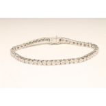 A DIAMOND TENNIS BRACELET, the fifty illusion set stones each of approximately 0.032cts on an 18ct