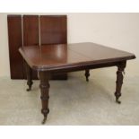 A VICTORIAN MAHOGANY EXTENDING DINING TABLE of rounded oblong form with three leaves and wind out
