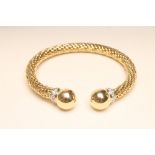 A "FOPE" 18CT GOLD TORQUE BANGLE, the cylindrical "fixed" chain with ball finials each with a collar