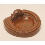 A ROBERT THOMPSON OAK ASHTRAY, the horseshoe dish surmounted by a mouse carved in high relief, 4 3/