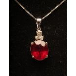 A RUBY AND DIAMOND PENDANT, the oval facet cut ruby claw set below three brilliant cut diamonds to a