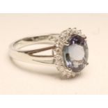 A TANZANITE AND DIAMOND RING, the oval cut tanzanite of approximately 3.35cts, claw set to a