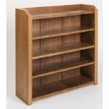 AN ADZED OAK OPEN BOOKCASE by Robert Thompson, the galleried top with dished ends, one with carved