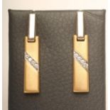 A PAIR OF "MOUAWAD" 18CT GOLD DROP EAR STUDS, the oblong matt panels each diagonally channel set