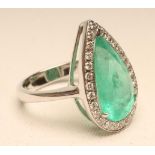 AN EMERALD AND DIAMOND COCKTAIL RING, the Colombian pear cut emerald of 5.29cts claw set to a border