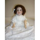 A French SFBJ bisque head character doll with brown glass sleeping eyes, open mouth and teeth, brown