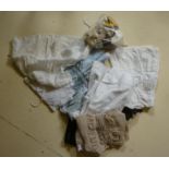 A quantity of dolls' clothing in cotton, and silk, dolls shoes and wigs (Est. plus 18% premium