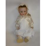 A Kammer & Reinhardt bisque head doll with brown glass sleeping eyes, open mouth and teeth, brown