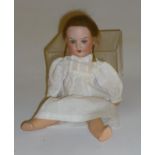 An Armand Marseille bisque head doll with blue glass sleeping eyes, open mouth and teeth, brown