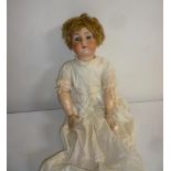 A Kammer & Reinhardt bisque head doll with blue glass sleeping eyes, open mouth and teeth, light