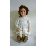 An Armand Marseille bisque head doll with blue glass sleeping eyes, open mouth and teeth, brown