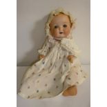 An Armand Marseille bisque head baby doll with blue glass sleeping eyes, open mouth and teeth,