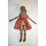 A carved wood doll, mid 19th century, with articulated arms and legs, spoon shaped hands, inset