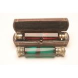 A VICTORIAN RUBY GLASS DOUBLE ENDED SCENT BOTTLE of panelled cylindrical form with one hinged and