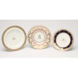 THREE ENGLISH PORCELAIN ARMORIAL DISHES comprising a Spode soup plate, c.1820, with two green fish