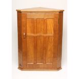 AN ADZED OAK CORNER CUPBOARD by Alan Grainger, the moulded edged top over six panel door with lug