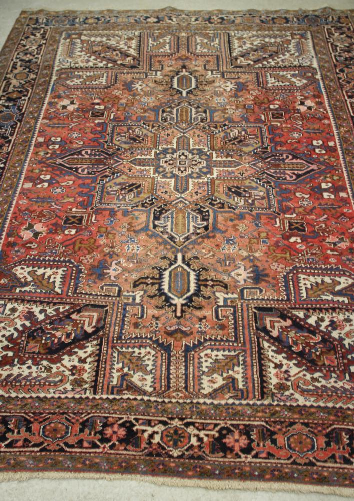 A PERSIAN WOOL CARPET, 20th century, the red floral field with large central star shaped gul and