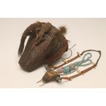 A KONYAK HEAD HUNTER BASKET, early 20th century, with mounted mammal skull and four tails, 9 1/2"