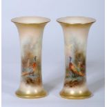 A PAIR OF ROYAL WORCESTER CHINA VASES, 1921, of waisted cylindrical form painted in polychrome