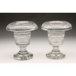 A PAIR OF IRISH STYLE GLASS URNS with diamond and slice cut turnover rims, similar panel cut