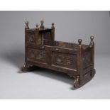 A JOINED OAK PANELLED CRIB, late 17th century, with turned finials on square section corner