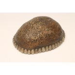 A TIBETAN KAPALA CEREMONIAL SKULL CUP, the exterior carved with designs, the rim decorated with