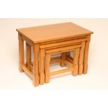 AN OAK NEST OF THREE TABLES by Coxwold Cabinetmakers, of oblong form raised on faceted and block