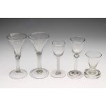 A COLLECTION OF FIVE WINE GLASSES, mainly Georgian, comprising a round funnel bowl on a double