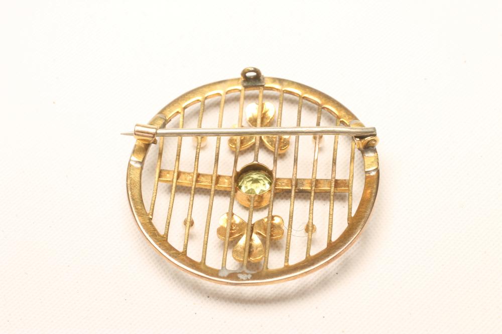 AN EDWARDIAN CIRCULAR BROOCH, centred by an open back collet set peridot flanked by two seed pearl - Image 2 of 2