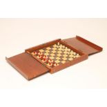 AN EDWARDIAN TRAVELLING CHESS SET by Jacques, with natural and stained red bone pegged Staunton type