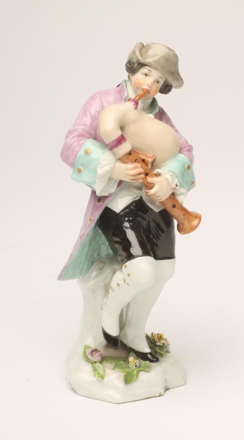 A SAMSON PORCELAIN FIGURE, late 19th century, of a young male bagpipe player wearing a grey hat