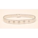 A 14KT WHITE GOLD BRACELET, the matt brick link tapering bracelet centred by five round brilliant