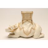 JAMES HADLEY FOR ROYAL WORCESTER-A CHINA CAMEL, c.1890, modelled recumbent with a gilt highlighted