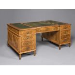 A WALNUT PEDESTAL DESK, early 20th century, the moulded edged inverted breakfront top lined in green