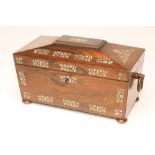 A REGENCY ROSEWOOD TEA CADDY of sarcophagus form with ring handles and raised upon four bun feet,