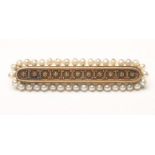 A VICTORIAN GOLD AND SEED PEARL BROOCH, the rounded oblong bar centred by cannetile work within a