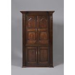 A GEORGIAN OAK STANDING CORNER CUPBOARD, mid 18th century, the inverted breakfront and moulded