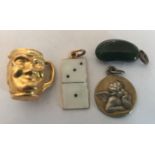 Four charms including 9ct gold and enamel domino and 9ct gold toby jug.