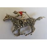 A diamond and enamel horse and jockey brooch the horse with ruby set eyes some enamel losses