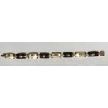 Nine carat gold and mother of pearl and onyx bracelet with Chinese characters.