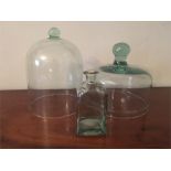 Two glass cloches and a clear glass bottle
