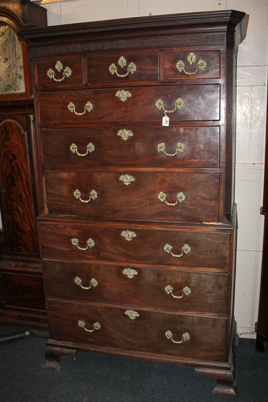 A George III mahogany chest on chest with dentil carving and blind fret cut frieze, above three